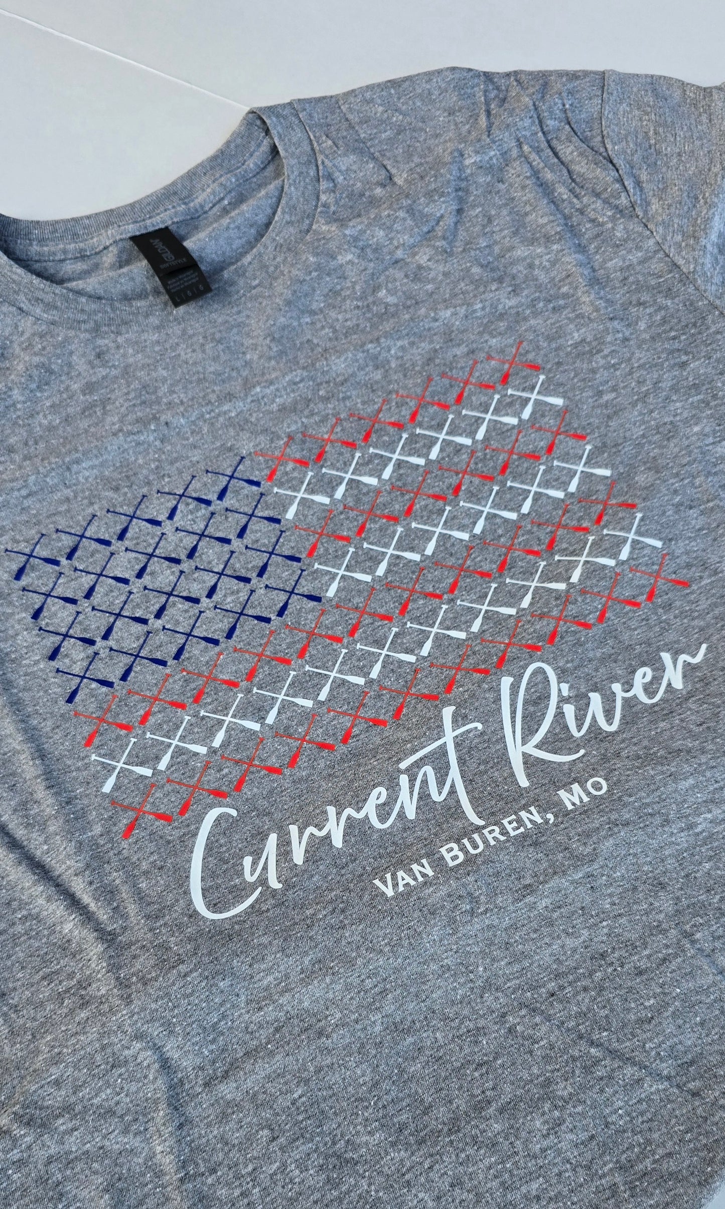 Heather gray t-shirt with a graphic design of multiple canoe paddles arranged to look like a US Flag. The text "Current River Van Buren, Mo" is at the bottom. 